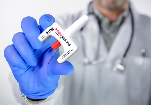 Medical professional holding a 4 mg Narcan nasal spray used to reverse opioid overdoses.