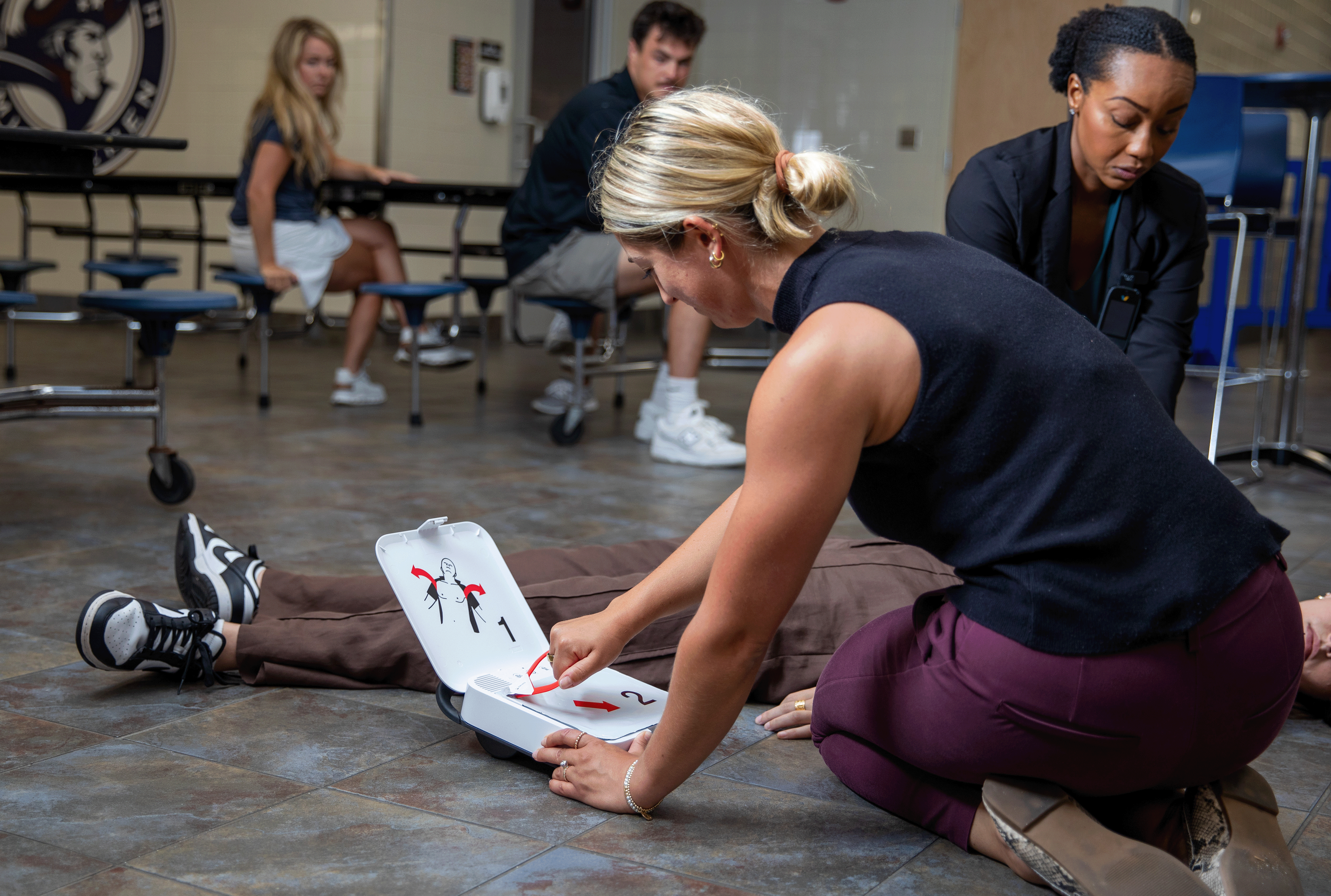 Bystander applying CR2 AED pads on a person experiencing sudden cardiac arrest