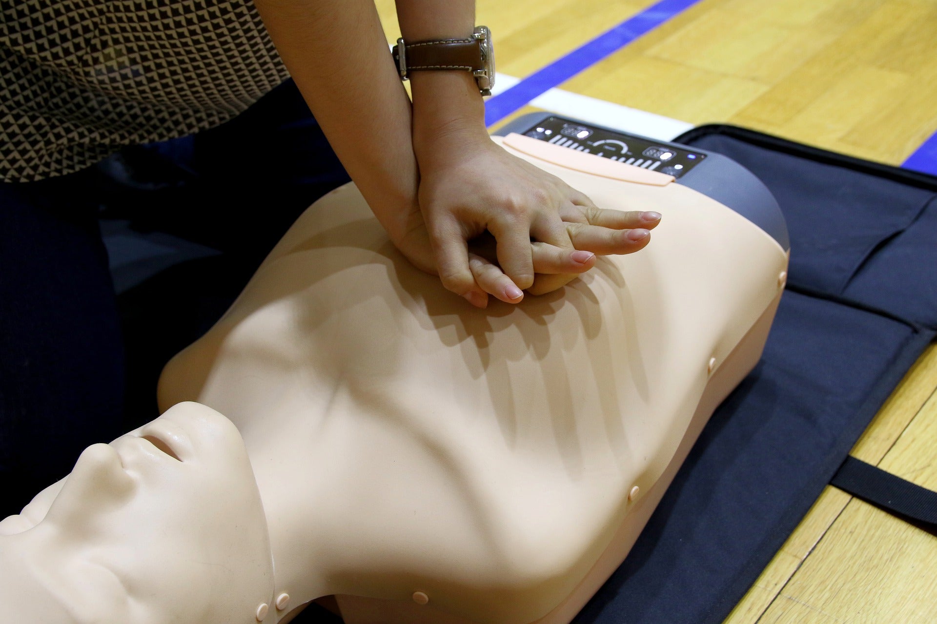 Person performing CPR on a training manikin during a first aid class