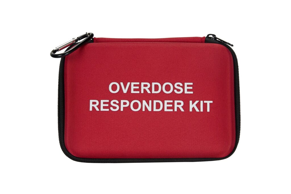 Red Overdose Responder Kit with white text on the front and a black zipper, featuring a carabiner clip on the top left corner.