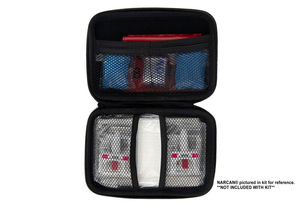 Open red Overdose Responder Kit showing mesh compartments with medical supplies inside.