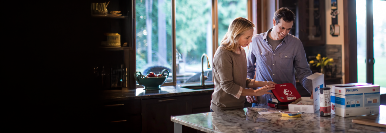 A group of girls responding to an emergency on a basketball court with an AED.